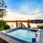 Awesome water view with hot tub in summer evening. House exterior.